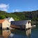 Small waterfront houses surrounded by a forested landscape in Maloy, Norway